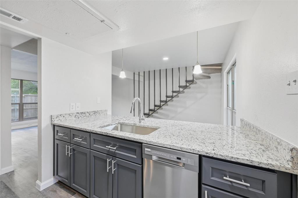 2702 Douglas Avenue, Unit 121 Dallas, TX 75219 - Photo 17 of 34 a kitchen with granite countertop a sink and a wooden floor
