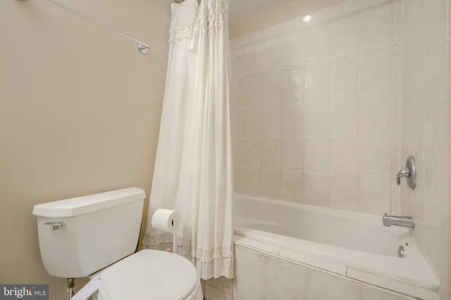 a white toilet sitting next to a bath tub