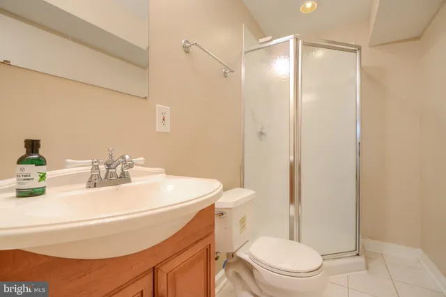 a bathroom with a sink a toilet a mirror and shower