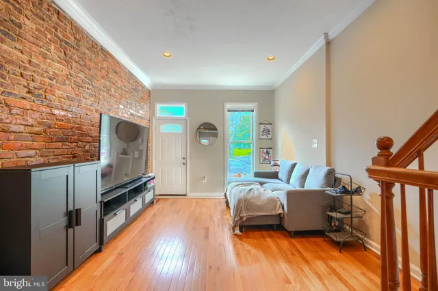 a living room with furniture a flat screen tv and a floor to ceiling window