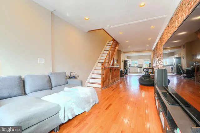 a living room with furniture and a wooden floor