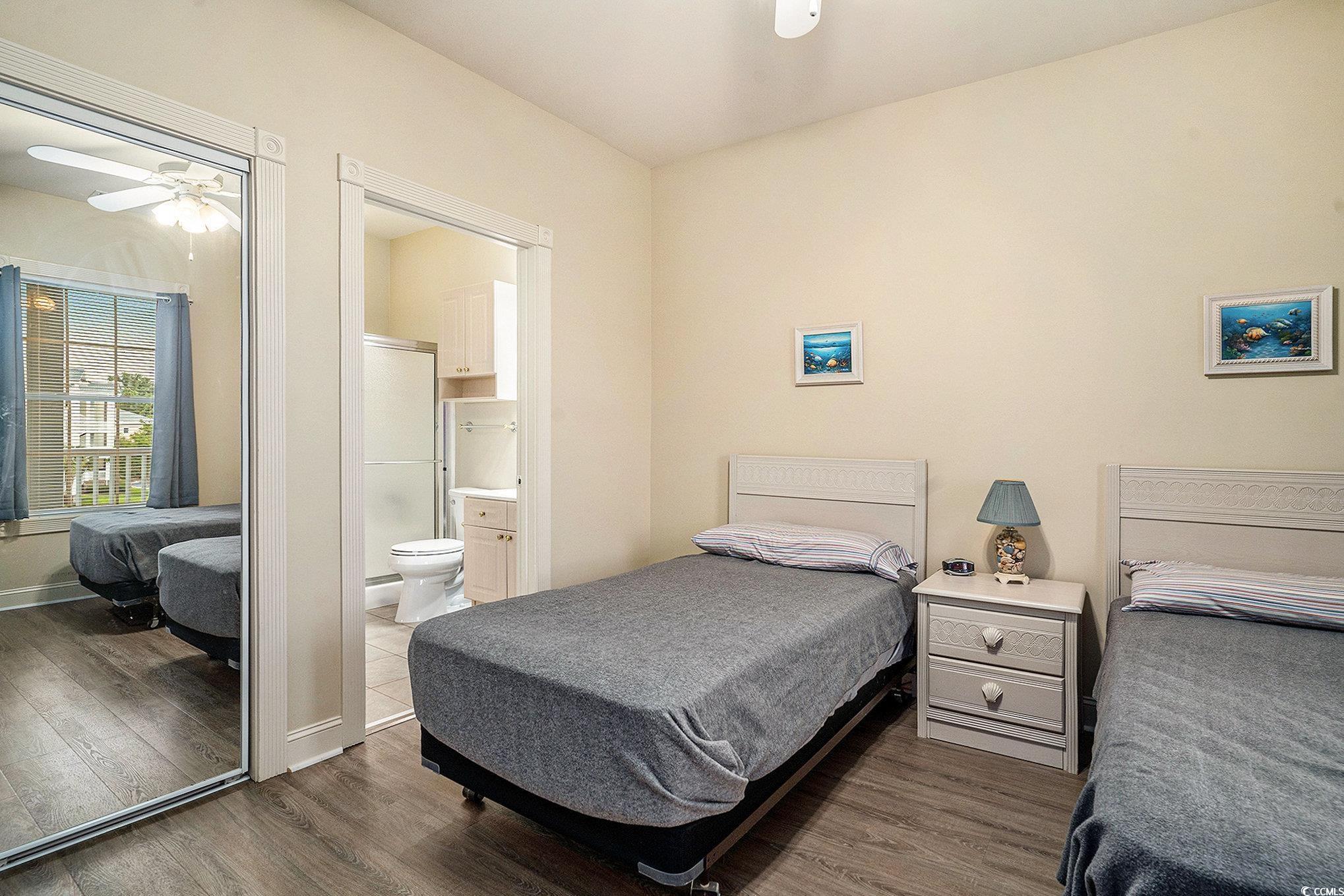 4895 Luster Leaf Circle, Unit 302 Myrtle Beach, SC 29577 - Photo 12 of 20 Bedroom with dark wood finished floors, ensuite ba