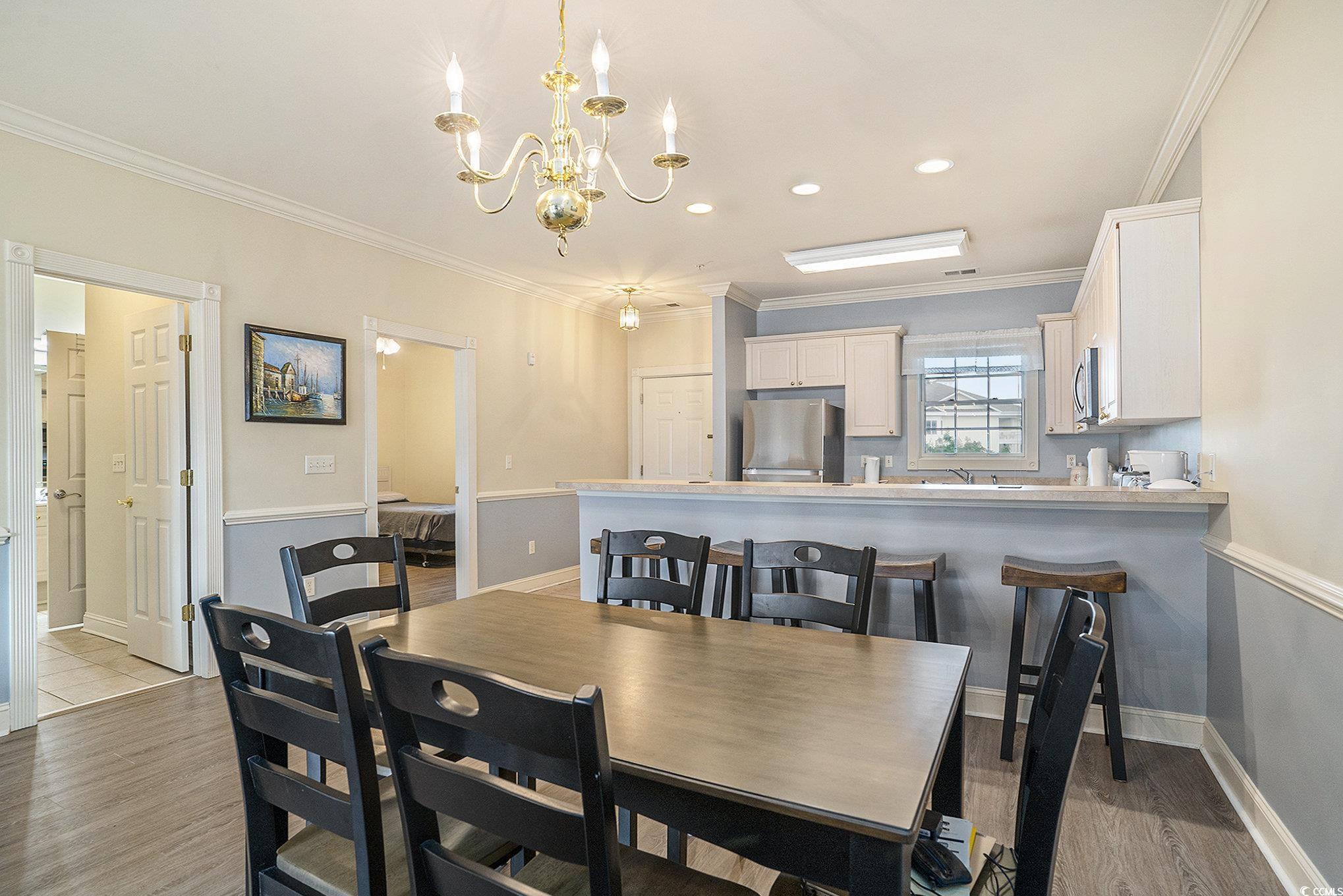 4895 Luster Leaf Circle, Unit 302 Myrtle Beach, SC 29577 - Photo 5 of 20 Dining area with a chandelier, crown molding, ligh