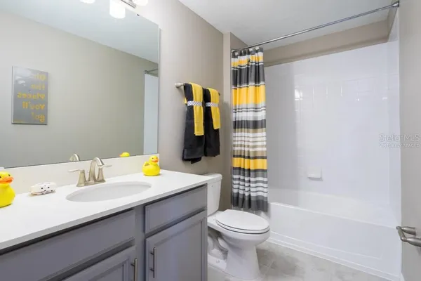 a bathroom with a sink vanity mirror and toilet