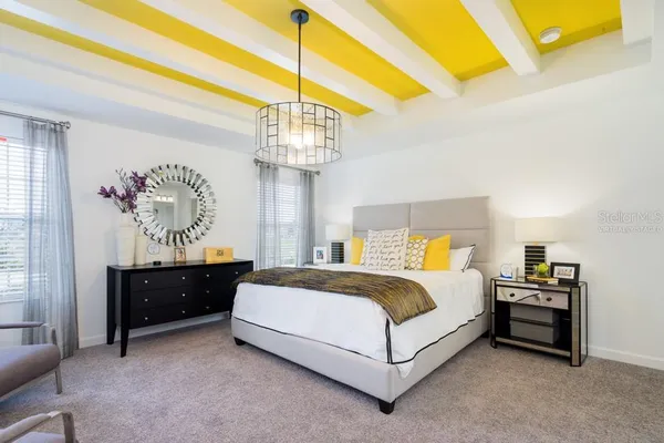 a spacious bedroom with a bed and a chandelier
