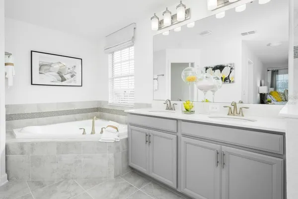 a bathroom with a tub a sink and mirror
