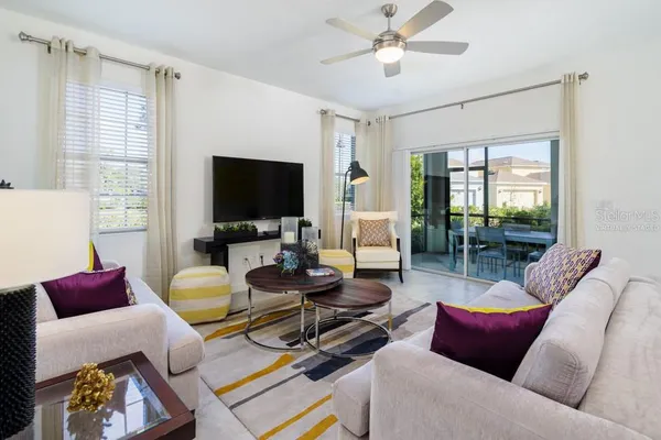 a living room with furniture a flat screen tv and a large window