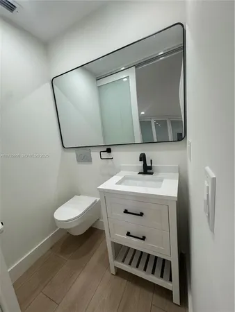 a bathroom with a sink mirror and toilet