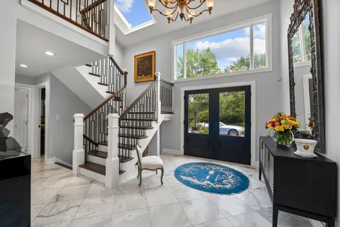 a kitchen with stainless steel appliances granite countertop a stove a sink a refrigerator and white cabinets