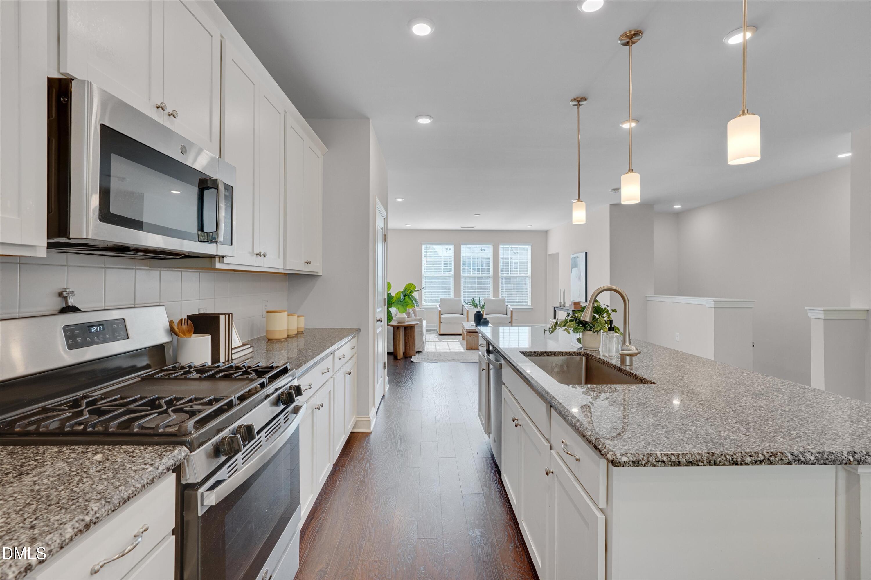 2819 Dallas Valley Lane Apex, NC 27502 - Photo 15 of 38 a kitchen with stainless steel appliances granite countertop a stove a sink and a microwave
