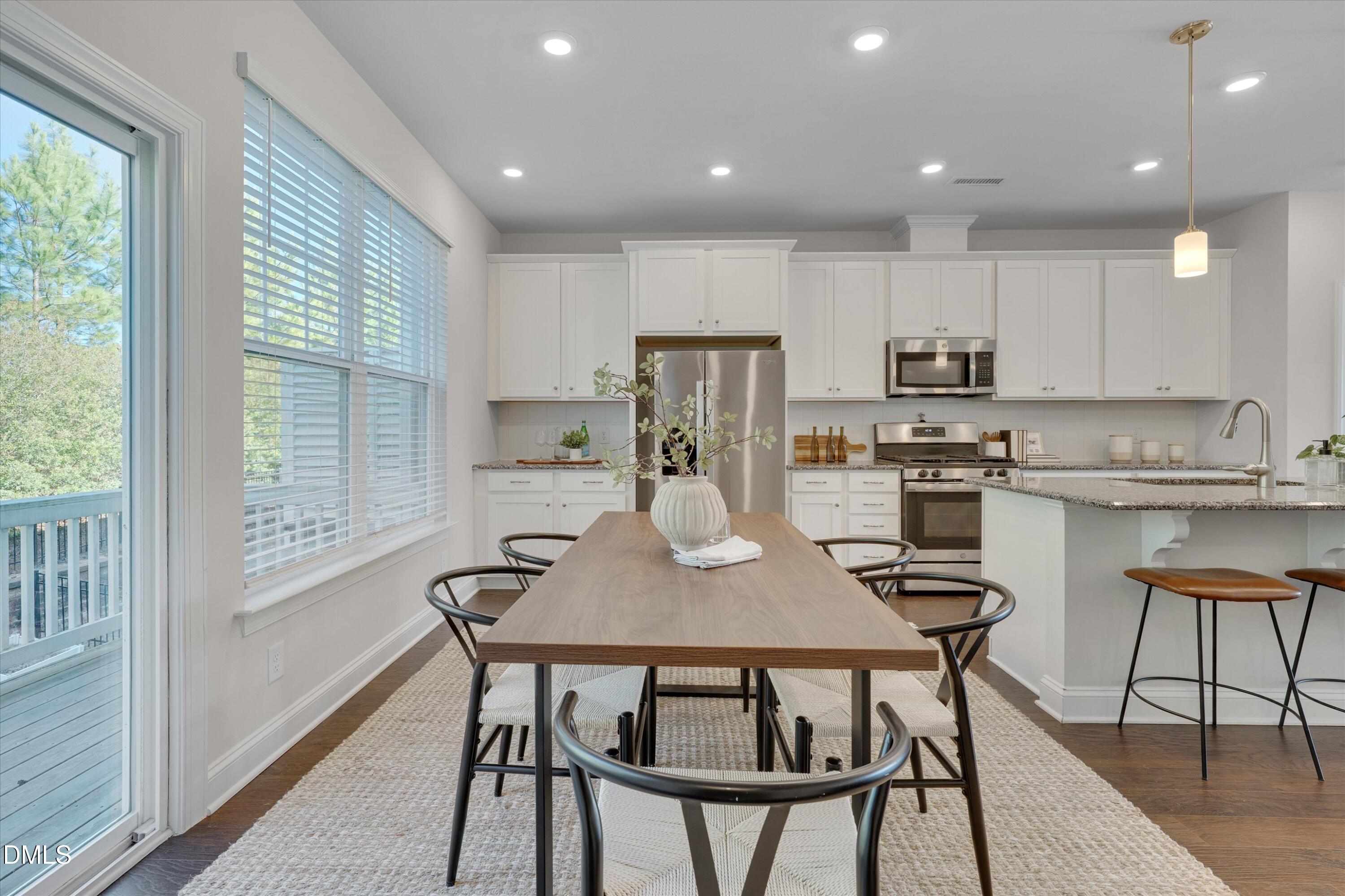 2819 Dallas Valley Lane Apex, NC 27502 - Photo 18 of 38 a kitchen with kitchen island a dining table and chairs