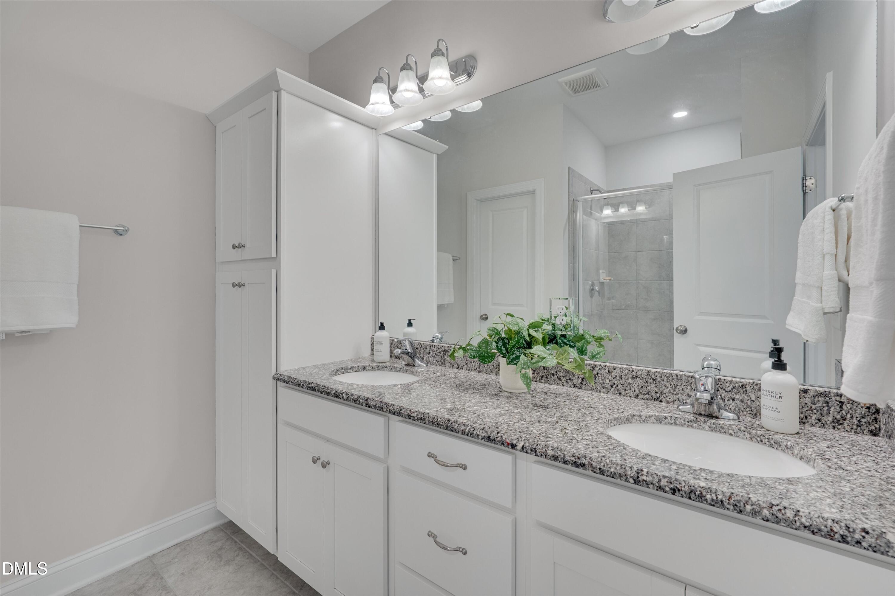 2819 Dallas Valley Lane Apex, NC 27502 - Photo 24 of 38 a bathroom with a granite countertop double vanity and a mirror