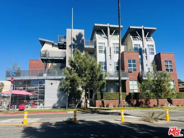 a front view of a building with street view and trees