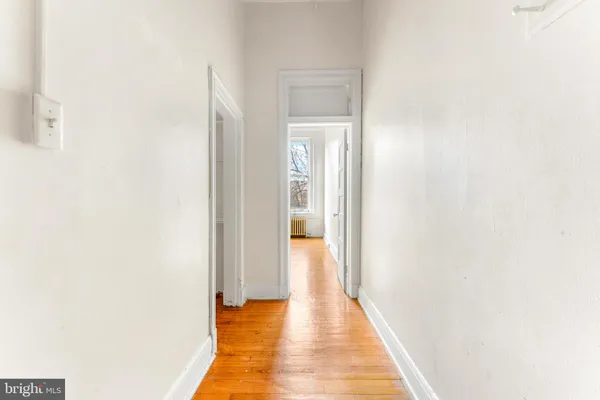 a view of a hallway with wooden floor