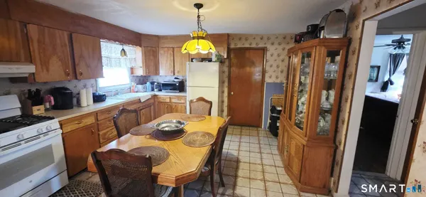 a dining room with stainless steel appliances furniture a window and kitchen view