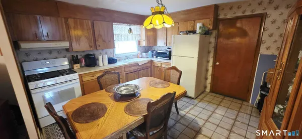 a kitchen with stainless steel appliances granite countertop a table chairs and a refrigerator