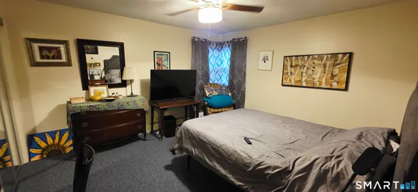 a bedroom with a bed and a flat tv screen on the dresser