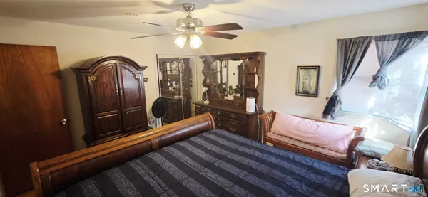 a bedroom with a bed and dresser with mirror