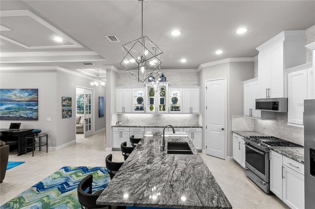 11075 Southwest 38th Boulevard Gainesville, FL 32608 - Photo 14 of 37 a large white kitchen with lots of counter space and stainless steel appliances