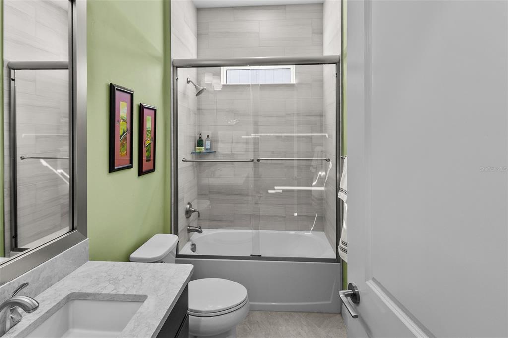 11075 Southwest 38th Boulevard Gainesville, FL 32608 - Photo 19 of 37 a bathroom with a granite countertop toilet sink and shower