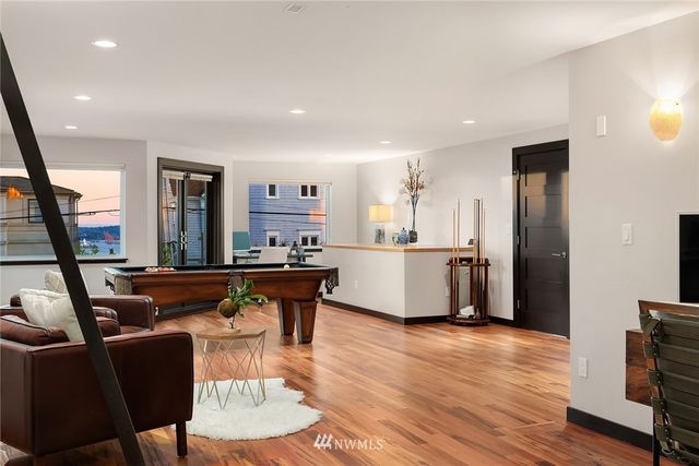 a living room with stainless steel appliances kitchen island granite countertop furniture and a wooden floor