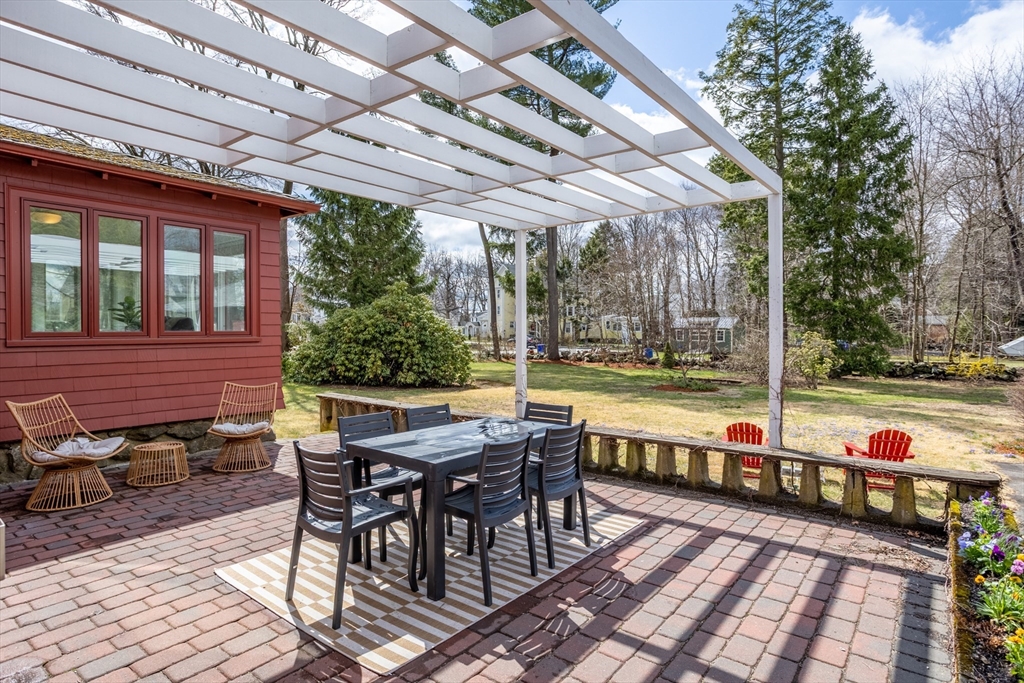 34 Fletcher Road Bedford, MA 01730 - Photo 29 of 42 a view of a patio with table and chairs and wooden floor