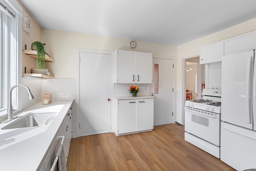 34 Fletcher Road Bedford, MA 01730 - Photo 10 of 42 a kitchen with a sink wooden floor and white appliances