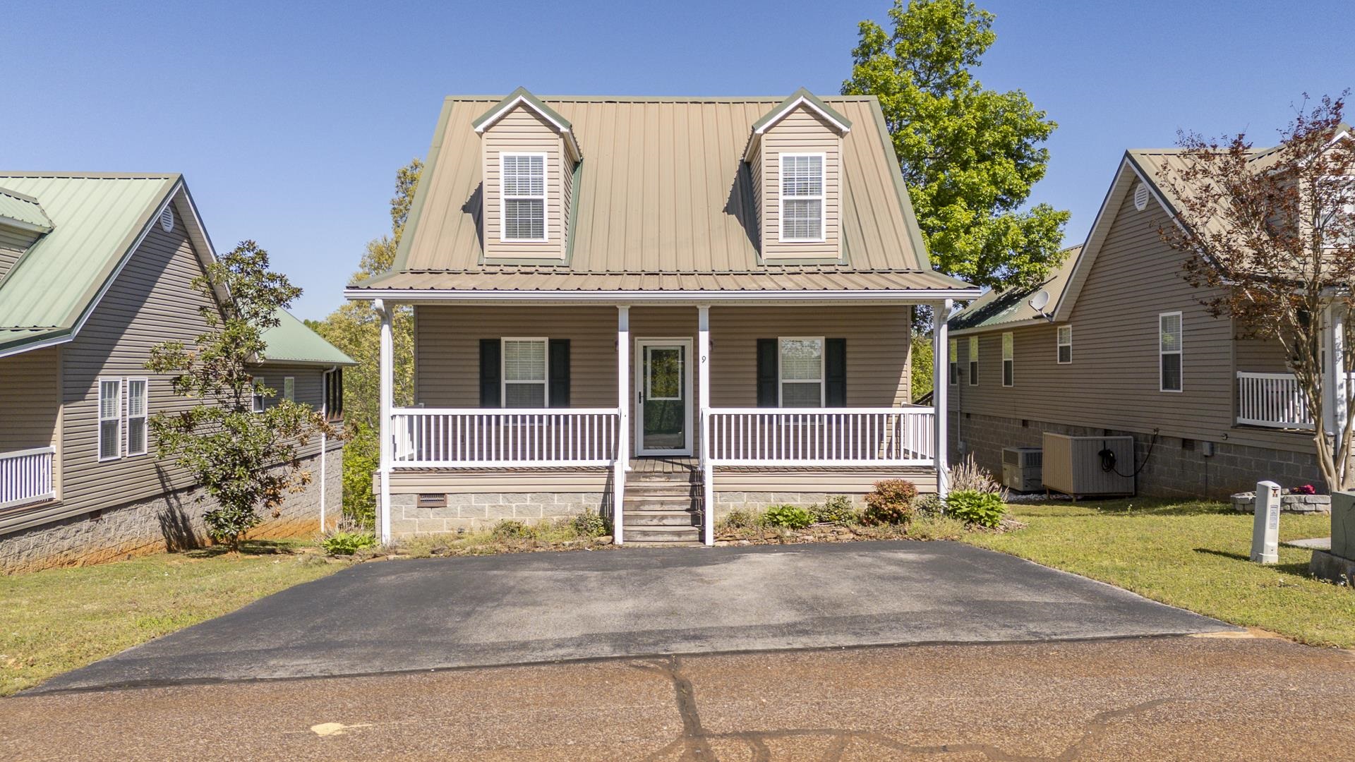 View of front of property with covered porch, a metal roof, a front yard, and crawl space