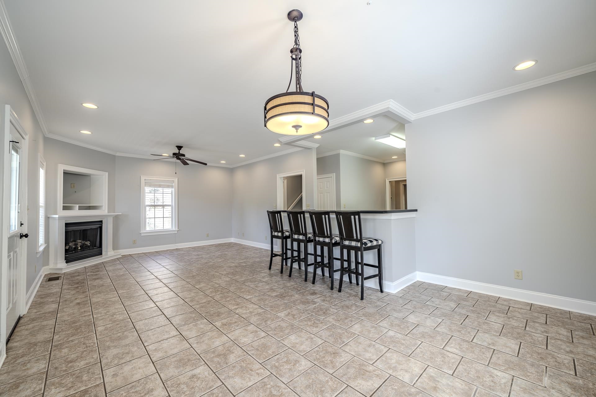 9 Mountain View Iuka, MS 38852 - Photo 3 of 32 Living area with a fireplace with raised hearth, recessed lighting, a ceiling fan, crown molding, and light tile patterned flooring