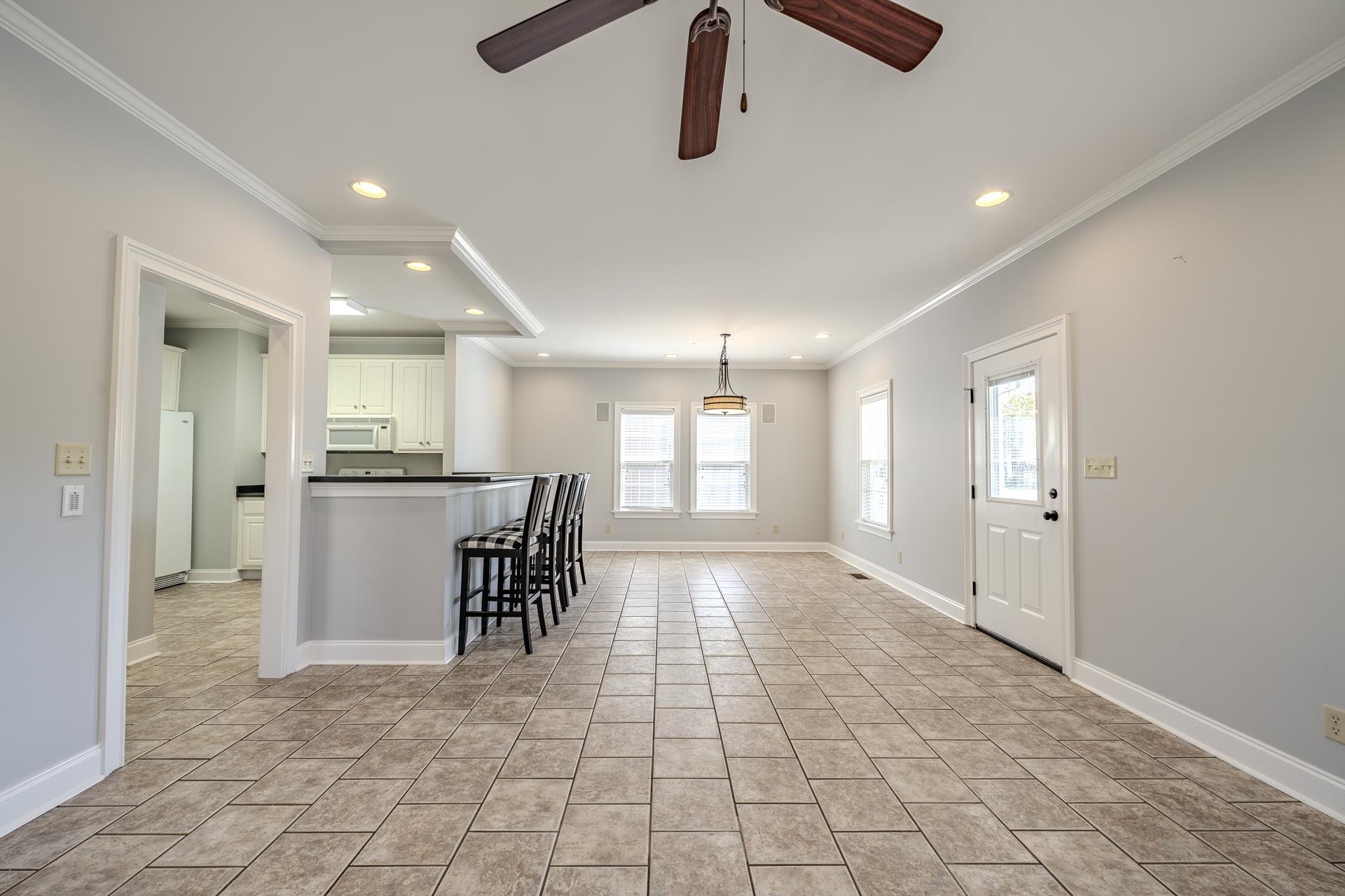 9 Mountain View Iuka, MS 38852 - Photo 4 of 32 Kitchen with dark countertops, a ceiling fan, a breakfast bar, decorative light fixtures, and white appliances