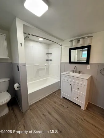 a bathroom with a sink a toilet a mirror and shower