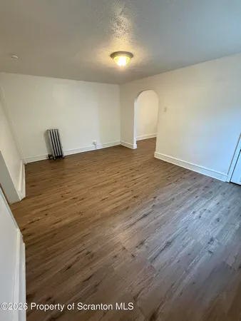a view of a room with wooden floor and window