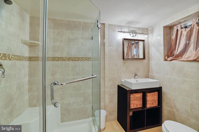 a bathroom with a sink a toilet a shower and a mirror