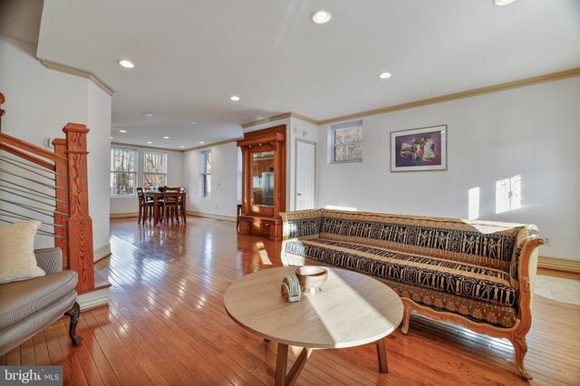 a living room with furniture and a dining table with wooden floor