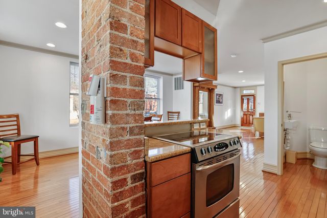 a kitchen with stainless steel appliances granite countertop a stove and a wooden floor