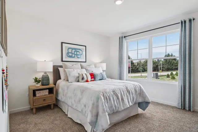 a bedroom with a bed and a large window
