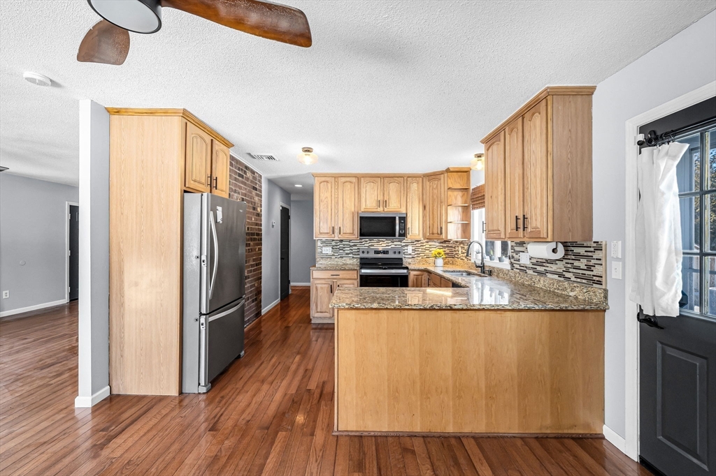 315 East Street South Suffield, CT 06078 - Photo 9 of 31 a kitchen with stainless steel appliances granite countertop a refrigerator a stove and a wooden floors