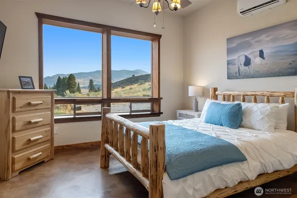 a bedroom with a bed and a large window