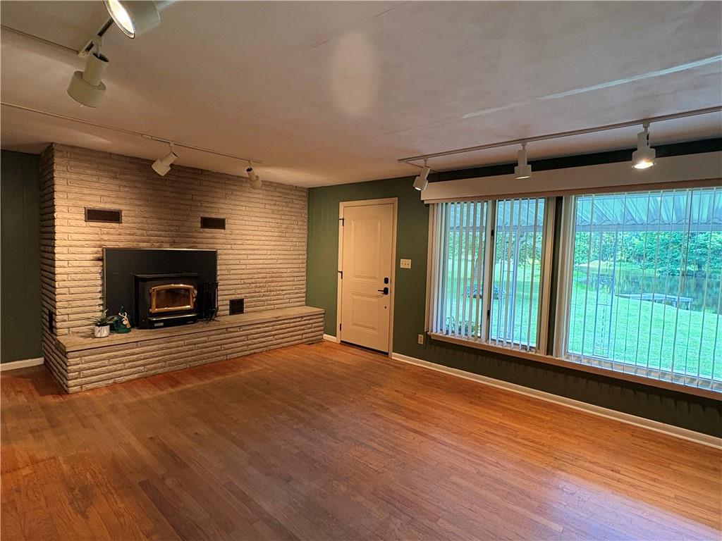320 Cherry Hill Road Greenville, PA 16125 - Photo 7 of 38 a view of an empty room with wooden floor fireplace and a window