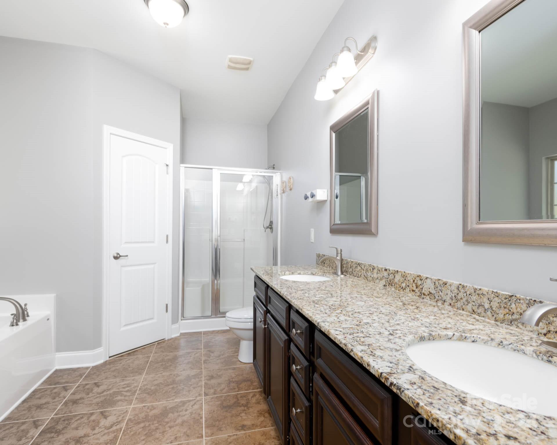 706 Houston Road Troutman, NC 28166 - Photo 18 of 39 a bathroom with a granite countertop sink and a mirror
