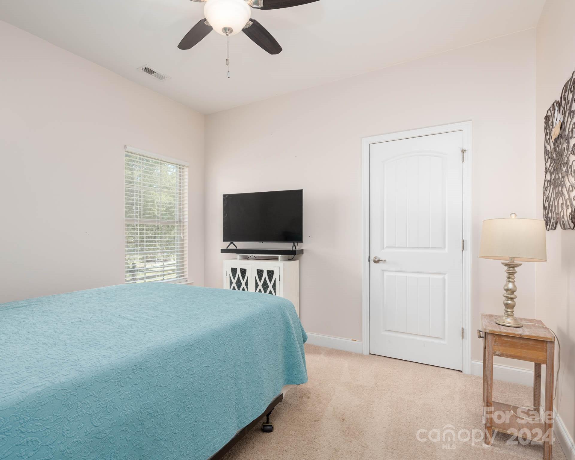 706 Houston Road Troutman, NC 28166 - Photo 25 of 39 a bedroom with a bed and a flat screen tv