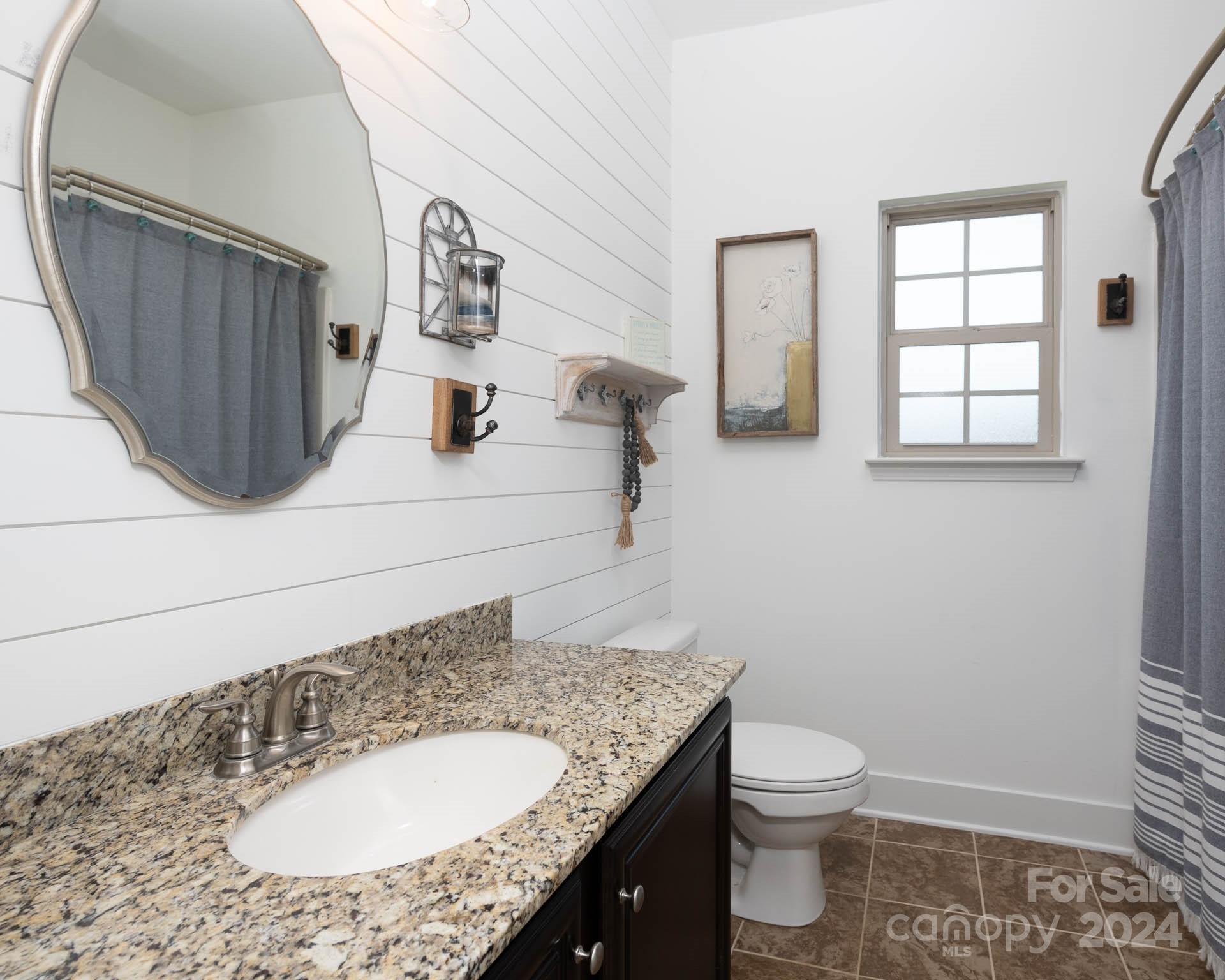 706 Houston Road Troutman, NC 28166 - Photo 26 of 39 a bathroom with a granite countertop sink toilet and mirror