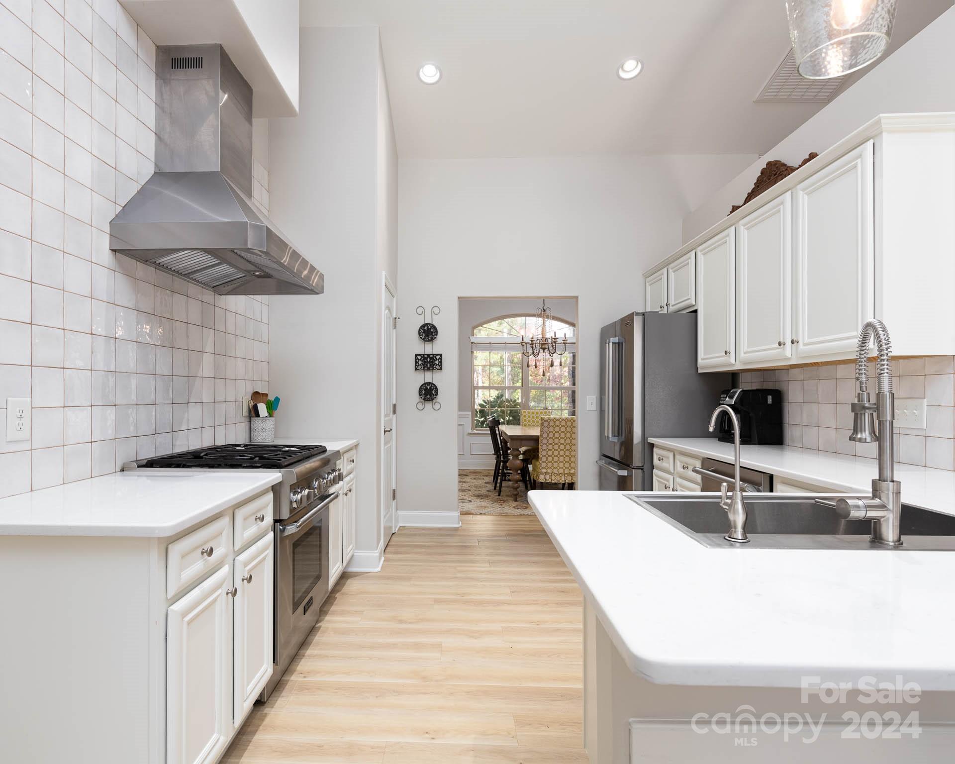 706 Houston Road Troutman, NC 28166 - Photo 10 of 39 a kitchen with stainless steel appliances granite countertop a sink stove and refrigerator