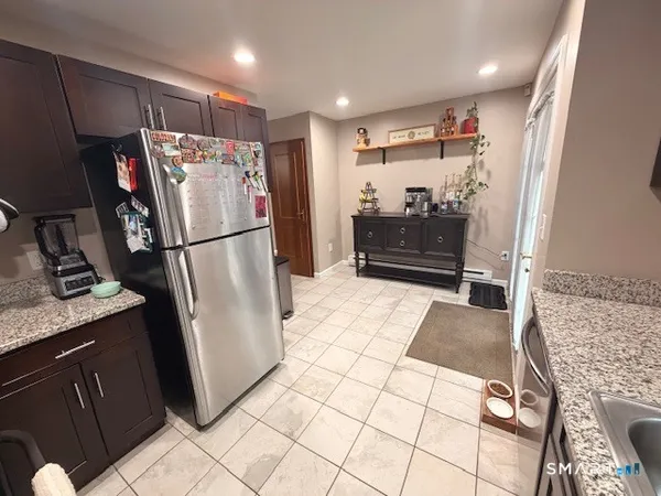 a kitchen with stainless steel appliances granite countertop refrigerator a stove top oven a sink and dishwasher