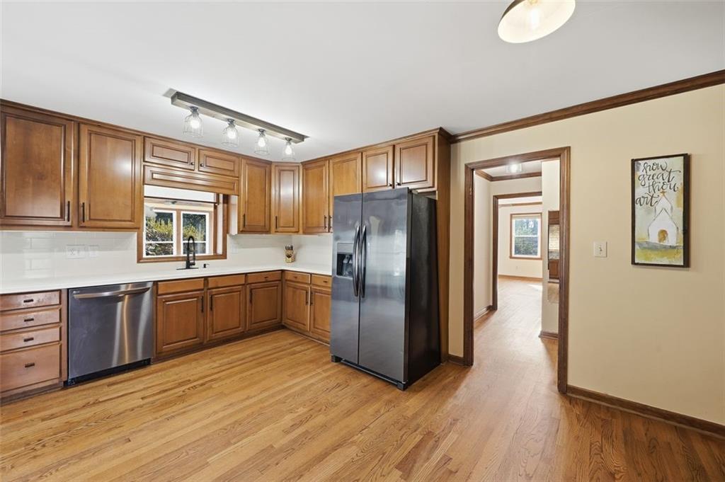 205 Hart Circle Dallas, GA 30132 - Photo 9 of 44 a kitchen with stainless steel appliances granite countertop a refrigerator a sink dishwasher a stove with wooden cabinets and floor