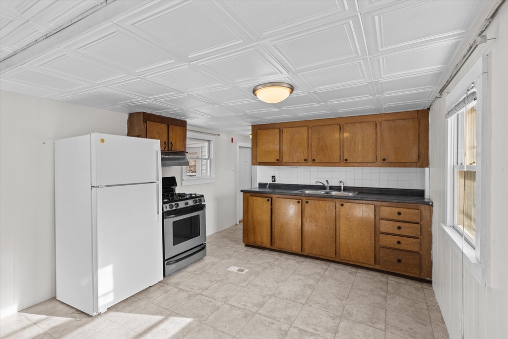 194 Lafayette Road, Unit 2E Salisbury, MA 01952 - Photo 2 of 23 a kitchen with granite countertop a refrigerator and a sink