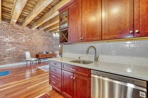 a living room with furniture a wooden floor and next to a window
