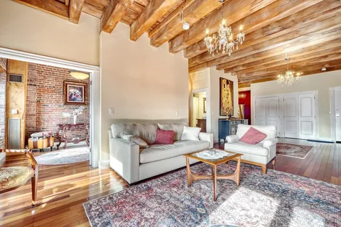 a view of a patio with couches chairs and wooden floor