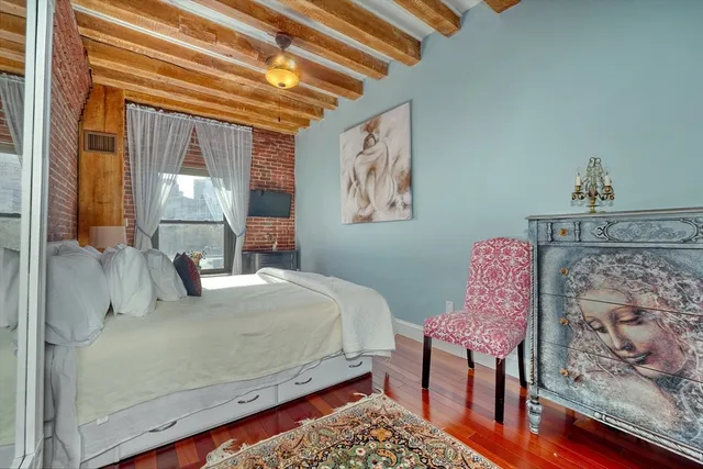 a bedroom with a bed and a painting on the wall