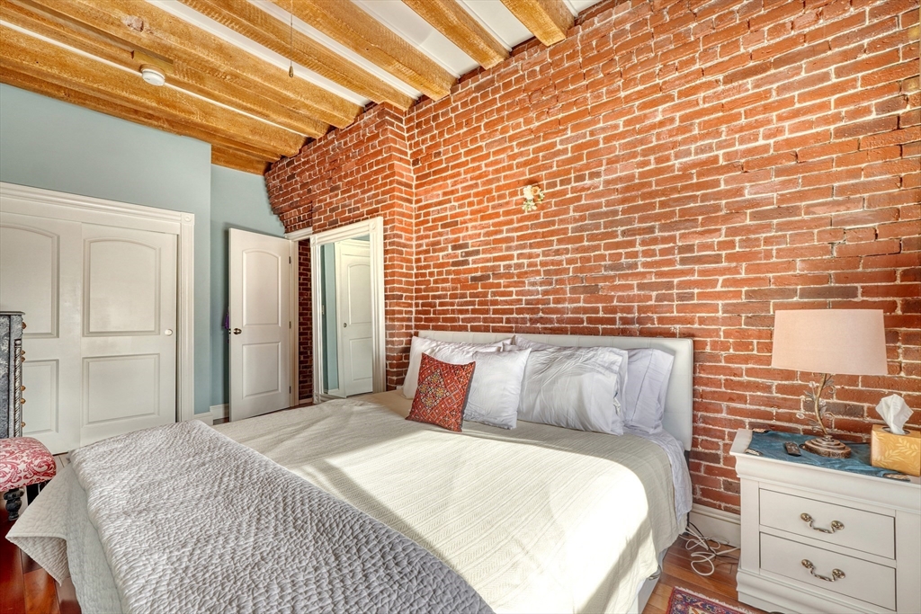 28-32 Atlantic Avenue, Unit 424 Boston, MA 02110 - Photo 24 of 38 a bedroom with a bed and dresser